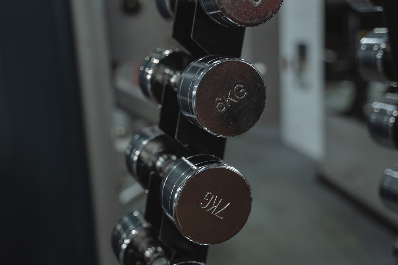 Metal dumbbells neatly arranged in a gym setting, ideal for fitness enthusiasts.