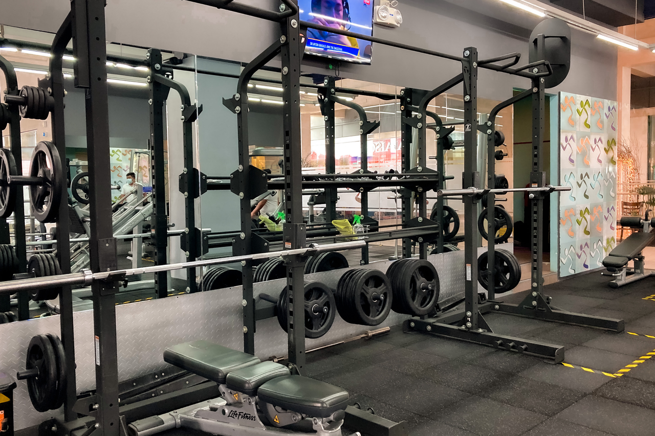 A spacious gym featuring benches, weights, and exercise machines for varied workouts.